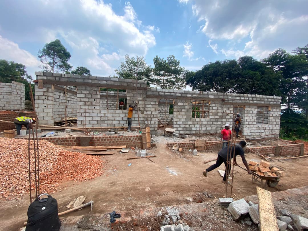 Workers building classroom walls at the school construction site